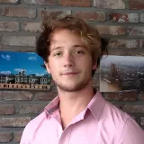 Portret van een MIRA-stagiair voor een bakstenen muur